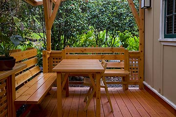 Volcano Bungalow - The covered lanai with hand-built benches and table welcomes you to spend time outdoors.
